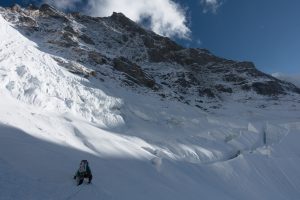 Alan Rousseau punching a trail through thigh deep snow to reach the fluted ramp access point to the north ridge. Photo: Tino Villanueva.