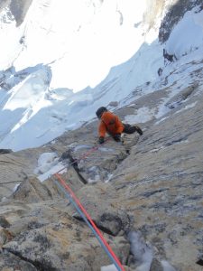 Crux pitch on day 2: an M6 iced up groove led to steep rock climbing, Villanueva writes. The fluted face they used to access the ridge is below his feet in the shadows. Photo: Alan Rousseau.