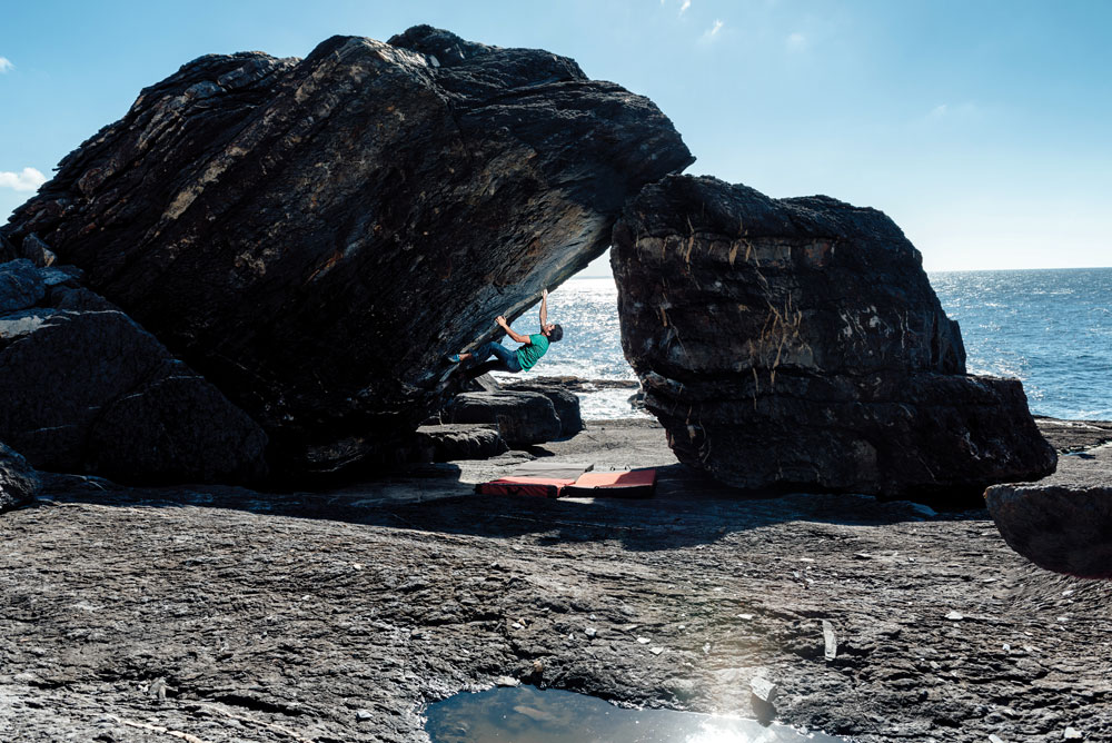Hector Alonso and a 7A/V6 at the seaside blocs at Cabo Negro. In wilder winters, the sea can move boulders around. Photo: Manuel Prats / 300Bolts. Hector Alonso and a 7A/V6 at the seaside blocs at Cabo Negro. In wilder winters, the sea can move boulders around. Photo: Manuel Prats / 300Bolts.
