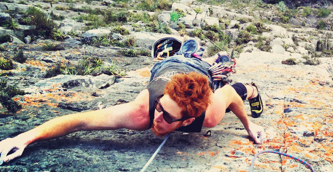A climber bears down on a vegetated multipitch. Tequila, anyone?